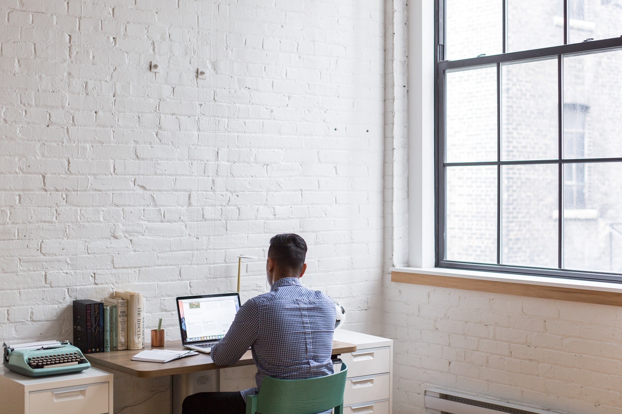 man-sitting-down-and-using-his-laptop-374085